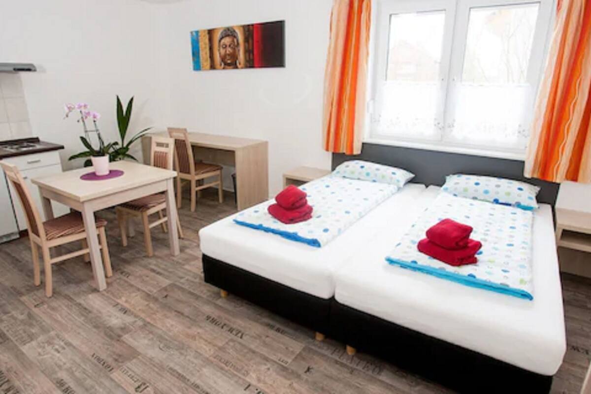 A bedroom with a bed, a desk, and a chair.