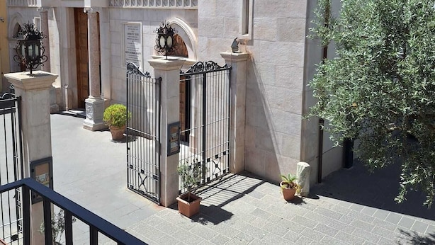 A historic building with a central entrance, arched doorways, and a bell tower. - Residenza Il Campanile (Sorrento)