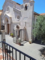 A historic building with a central entrance, arched doorways, and a bell tower.