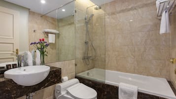 A modern bathroom with a glass-enclosed shower, a standalone bathtub, and a toilet.