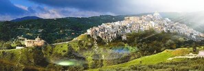 Un pueblo histórico con una iglesia destacada en una colina y una estructura que recuerda a un castillo.