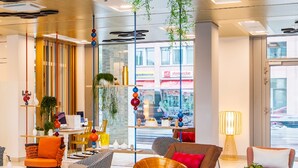 A modern lobby with a glass floor, colorful furniture, and a decorative wall with hexagonal patterns. - Capri by Fraser Berlin (Berlin)