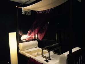 A dimly lit room with a bed, a laptop, and a lamp. - Rachamankha Thai Villa (Chiang Mai)