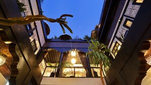 Vista de un patio con diseño arquitectónico tradicional, que cuenta con una zona de estar central y elementos decorativos.