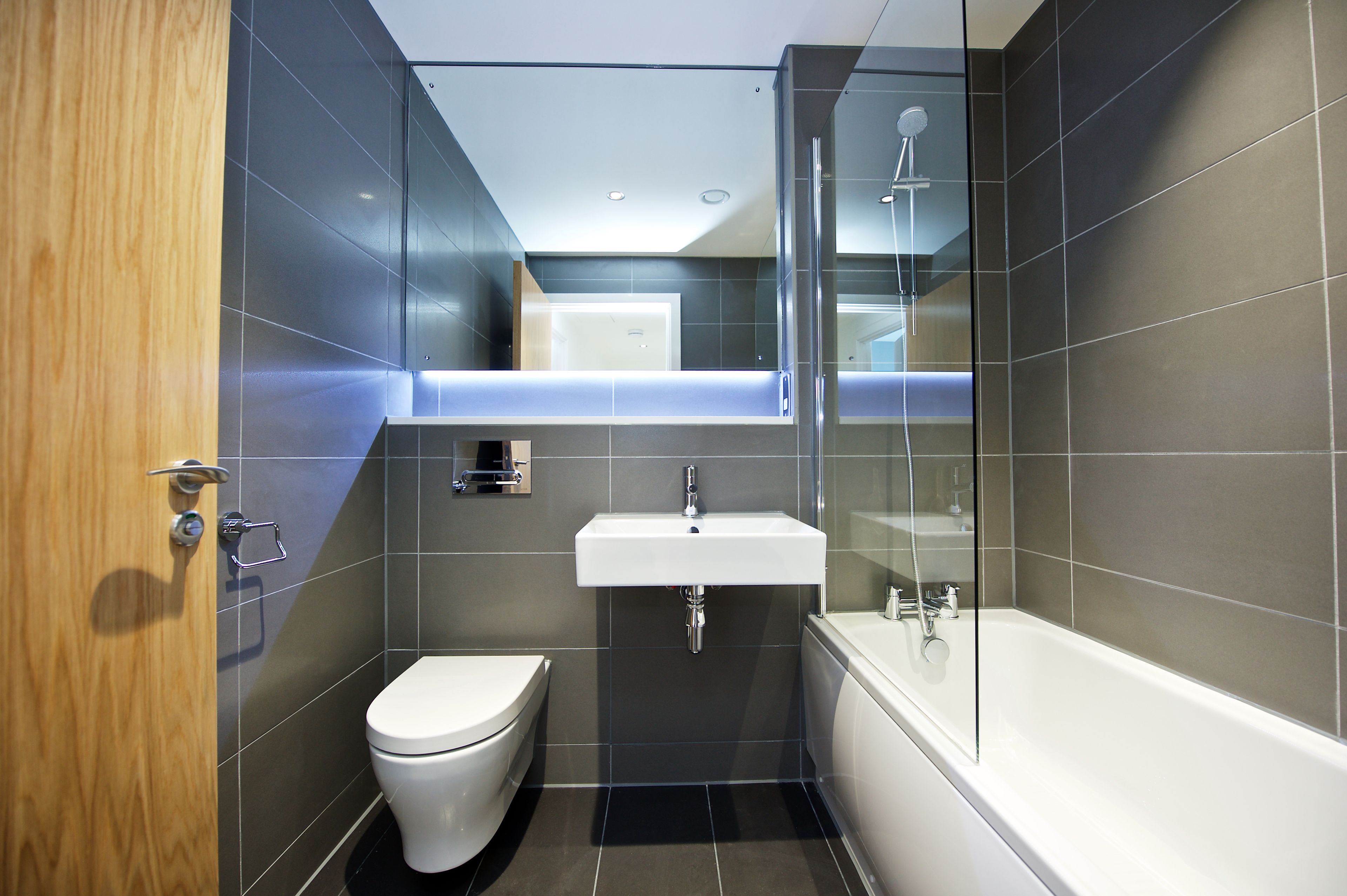 A modern bathroom with a toilet, sink, and bathtub.