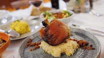 A plate with a roasted meat, sauerkraut, and a side dish.