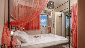 A bedroom with a bed, a bedside table, a window, and a door.