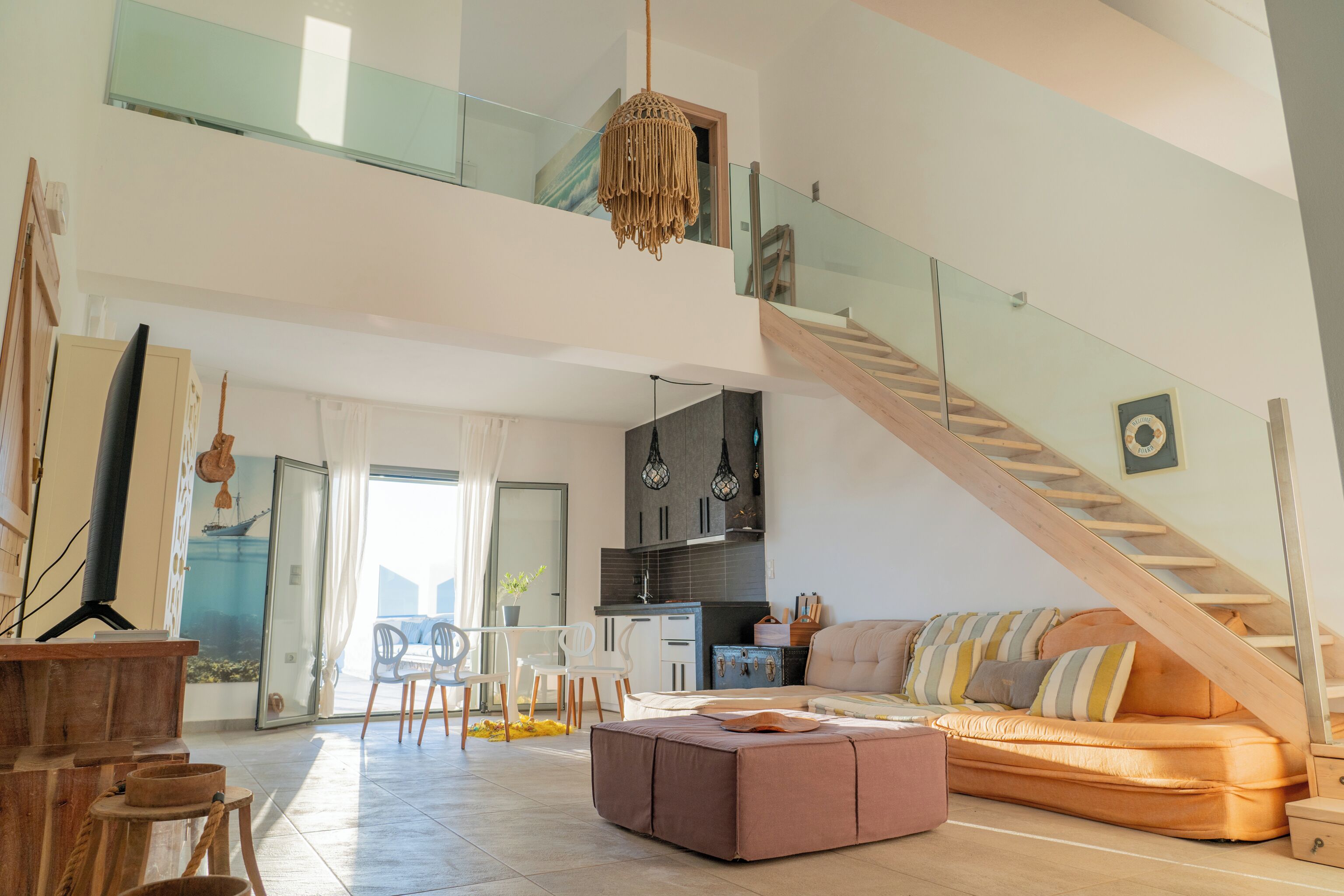 A spacious living area with a staircase, a sofa, and a dining area.
