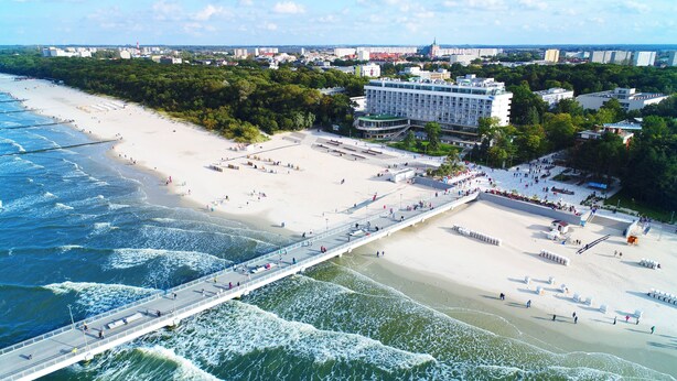 Een kuststreeatsilhouette met een strand, een boulevard en moderne gebouwen.