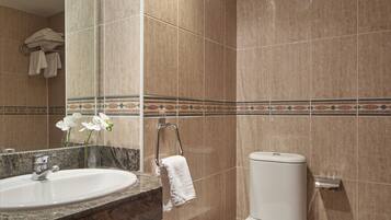 Une salle de bain équipée d’un lavabo, de toilettes et d’un bidet.