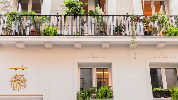 A hotel facade with multiple balconies, each with plants and a sign reading "HOTEL TEMPS". - Hotel du Temps Madrid (Madrid)