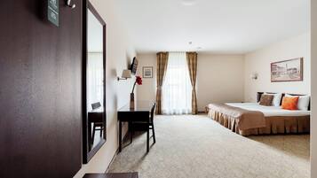 Quarto de hotel com cama, escrivaninha, cadeira, espelho, janela com cortinas e um quadro na parede.