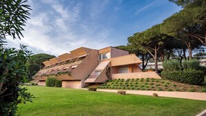 Un edificio moderno con techo inclinado y patio cubierto de césped.