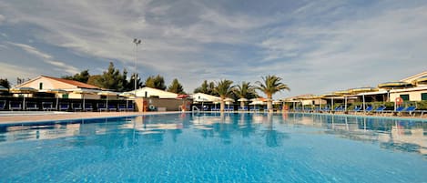 Una piscina al aire libre de temporada, sillones reclinables de piscina