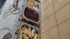 A buffet table with various food items and utensils. - Saffana Hôtel (Douala)