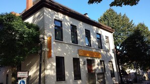Un immeuble avec une enseigne indiquant « Chambres à louer » et un panneau de sécurité incendie.