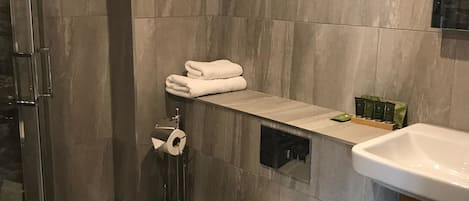 A modern bathroom with a toilet, a sink, and a shower area.