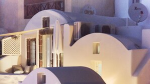 A white staircase with a handrail, leading to a door with a small window. - Anemi House & Villas (Santorini)
