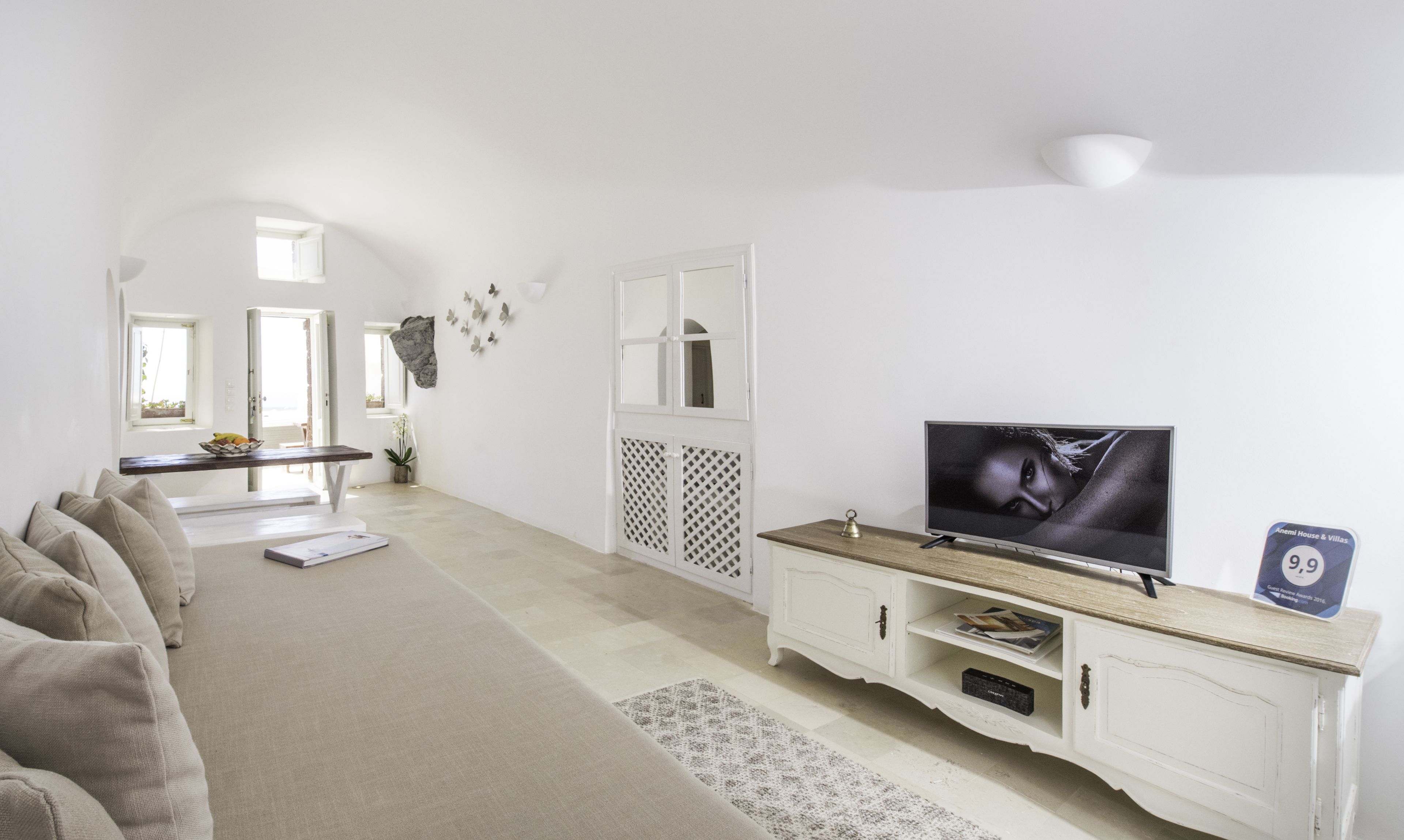 A modern living room with a television, sofa, and a decorative wall piece.