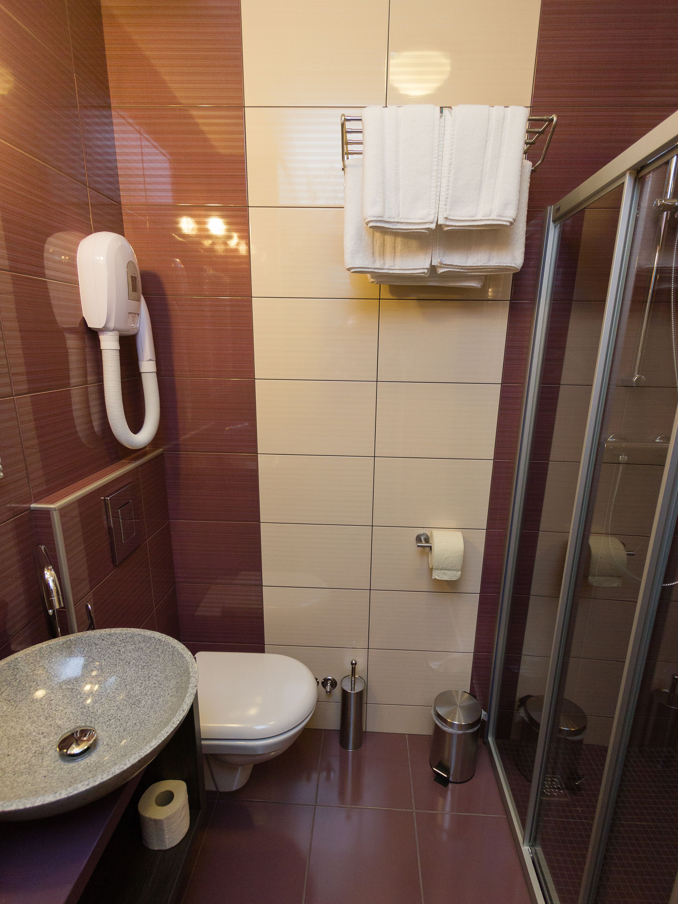 A bathroom with a toilet, sink, and shower.