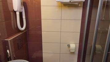 A bathroom with a toilet, sink, and shower.