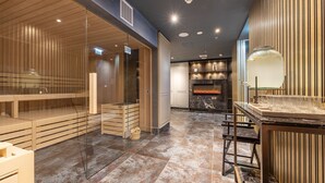 A modern interior with a wooden reception desk, a glass partition, and a stone fireplace. - Hotel Royal Prague (Prague)