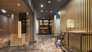 A modern interior with a fireplace, a glass-enclosed sauna, and a bar area. - Hotel Royal Prague (Prague)