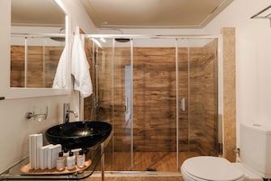 Suite Deluxe, vistas al mar | Baño | Ducha, artículos de higiene personal gratuitos, albornoces y zapatillas