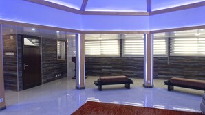 Un moderno cuarto de spa con pared de madera, una banca y una puerta.