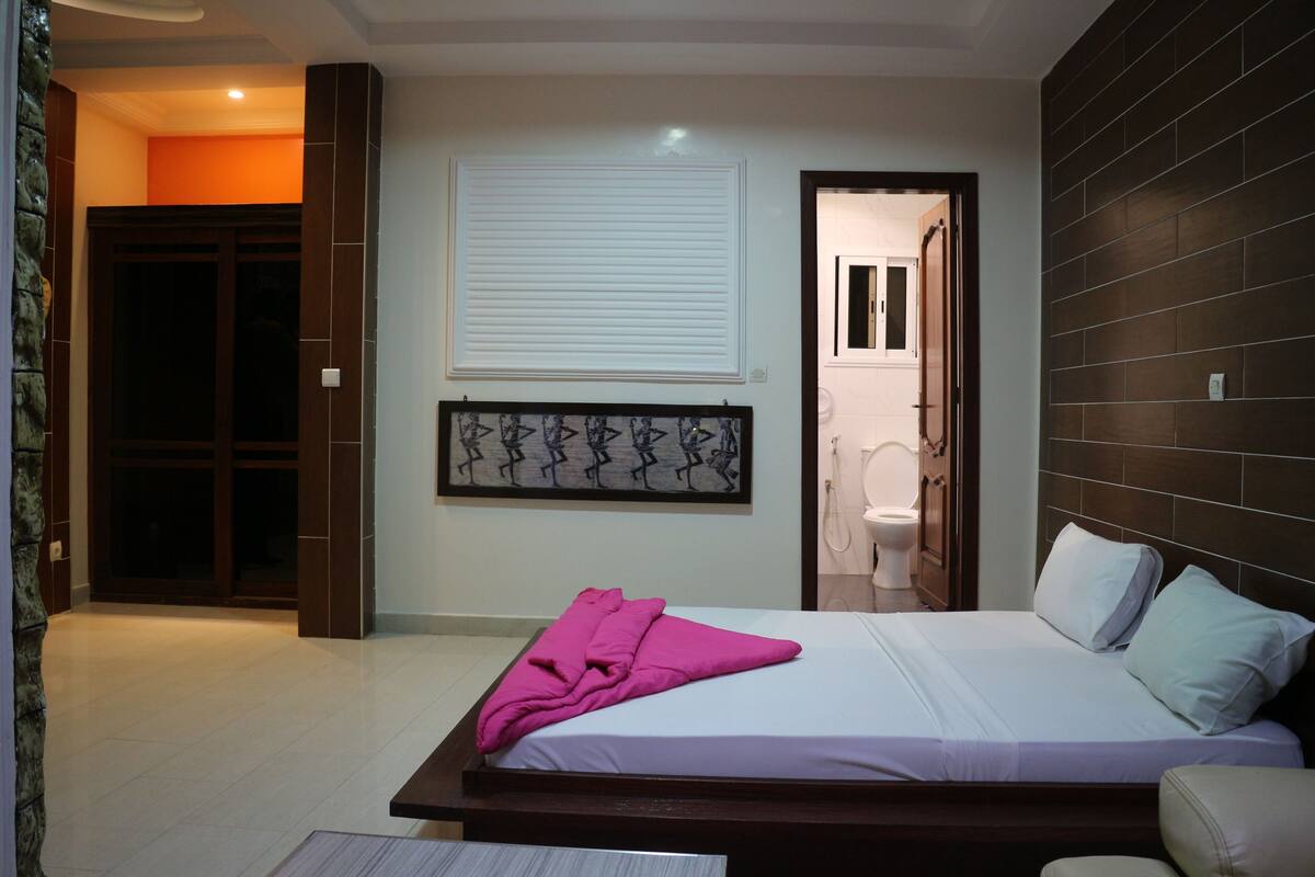 Une chambre d’hôtel comprenant un lit, une salle de bain et une porte donnant sur une autre pièce.