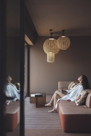 A modern interior with a sofa, a coffee table, and two hanging light fixtures. - Hotel Baia Azzurra (Arco)
