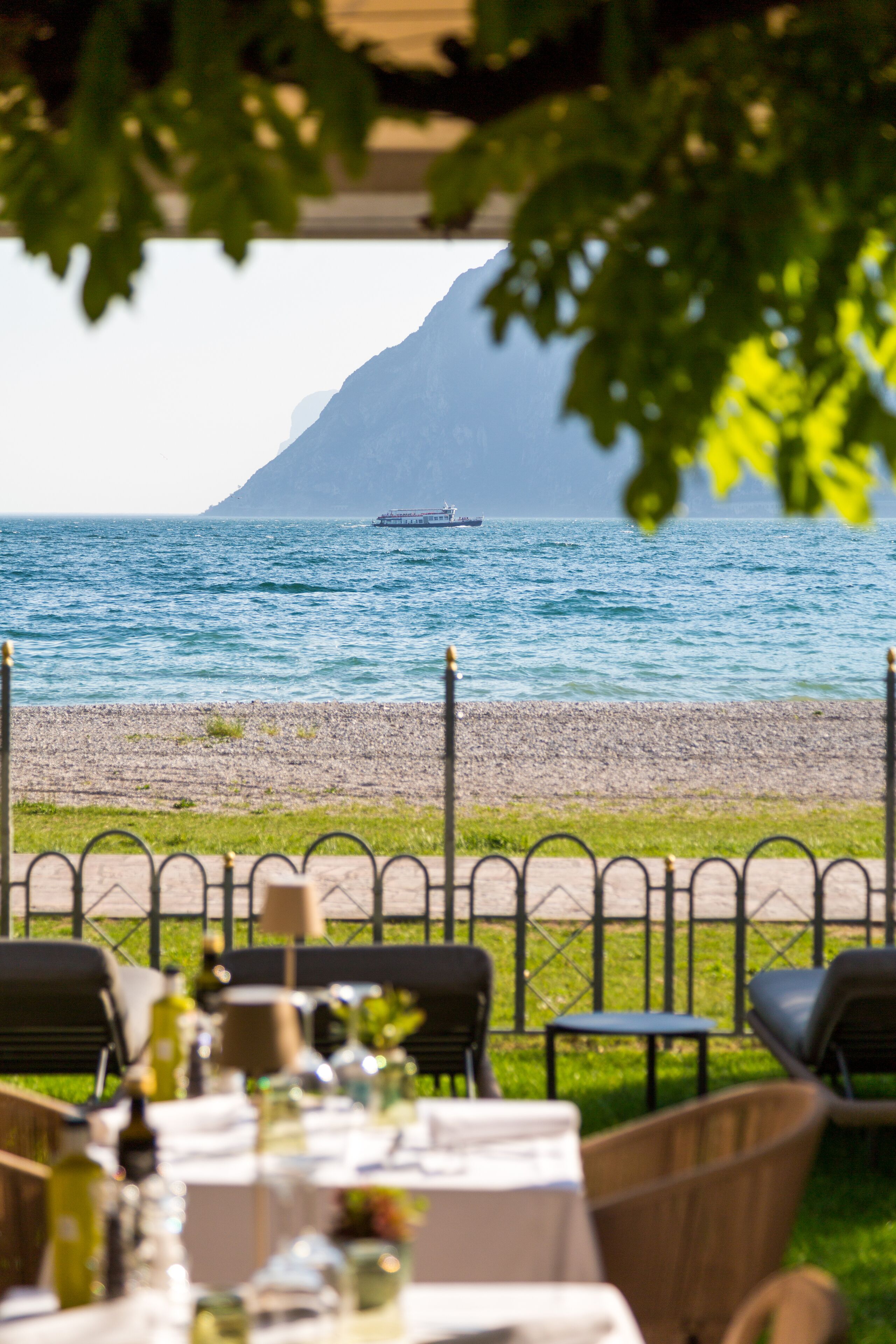 Un área de comedor al aire libre con vistas al mar y una montaña distante.