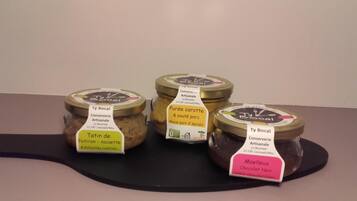 Quatre pots contenant des produits alimentaires, posés sur une surface noire.