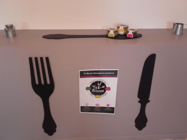 Una mesa con un camino de mesa negro, tres frascos de mermelada y una tarjeta con el logotipo 'Ty Bocal'.