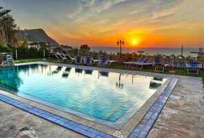 A swimming pool with lounge chairs and a sunset view. - Hotel Villa Cimmentorosso (Forio)