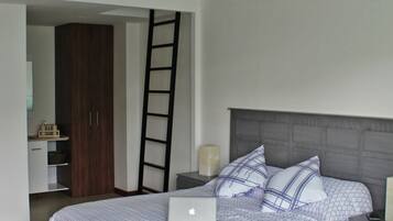 A bedroom with a bed, a laptop, a nightstand, a dresser, and a ladder.
