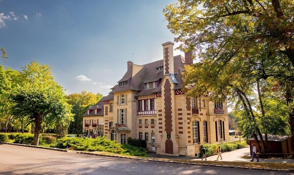 A historic building with a prominent tower, large windows, and a well-maintained garden. - Chateau de la Tour (Gouvieux)