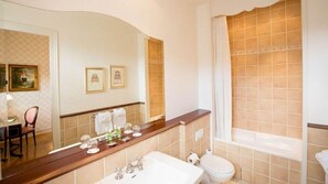 A bathroom with a large mirror, a sink, a toilet, and a bathtub.