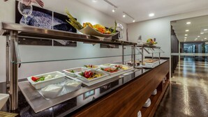Un bufé con diversos alimentos y una composición decorativa de cristalería.