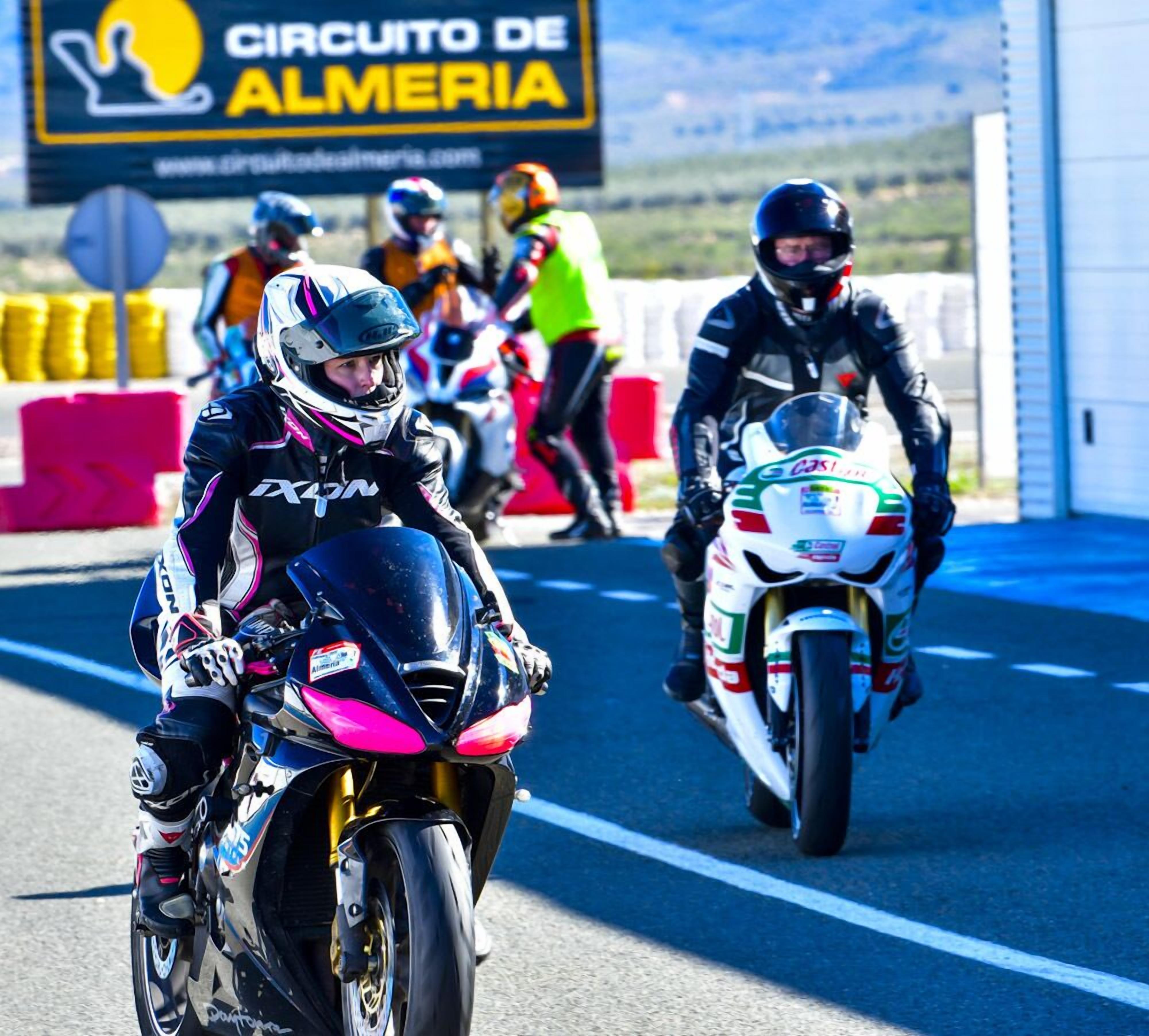 Ein Motorradrennen auf einer Rennstrecke, auf der ein Schild mit der Aufschrift 'CIRCUITO DE ALMERIA' steht.