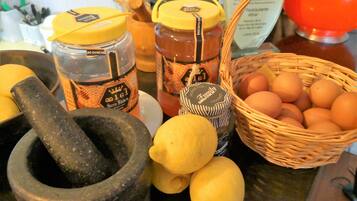 Una encimera de cocina con un mortero, limones, tarros de miel y una cesta de huevos.