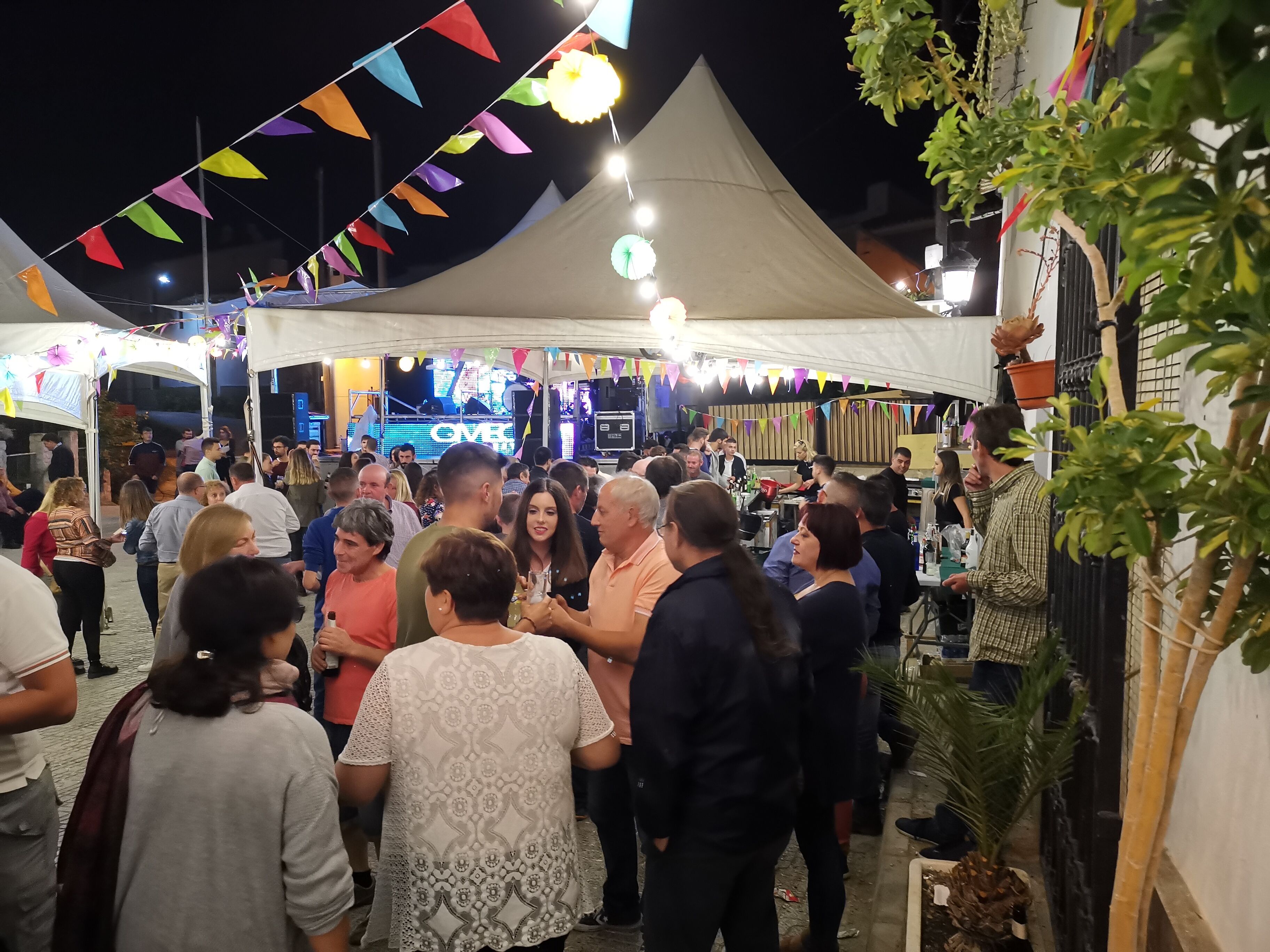A crowded outdoor event with tents and people gathered around.