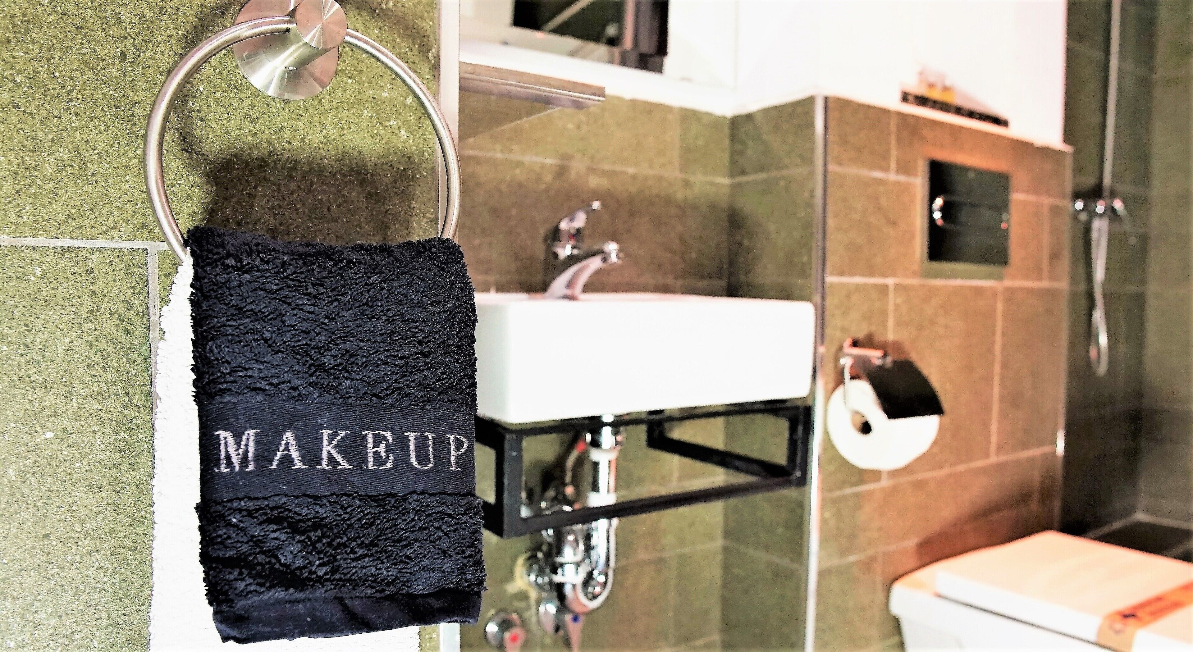 A bathroom with a sink, mirror, and towel rack.