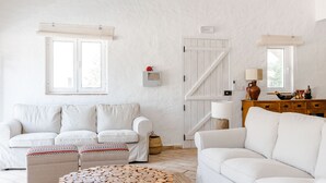 A modern living room with a white sofa set, a wooden coffee table, and a white door with a window. - Casa Das Cegonhas (Alcacer do Sal)