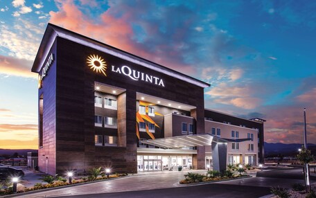 A modern hotel with a prominent 'LAQUINTA' sign, multiple floors, and a covered entrance.