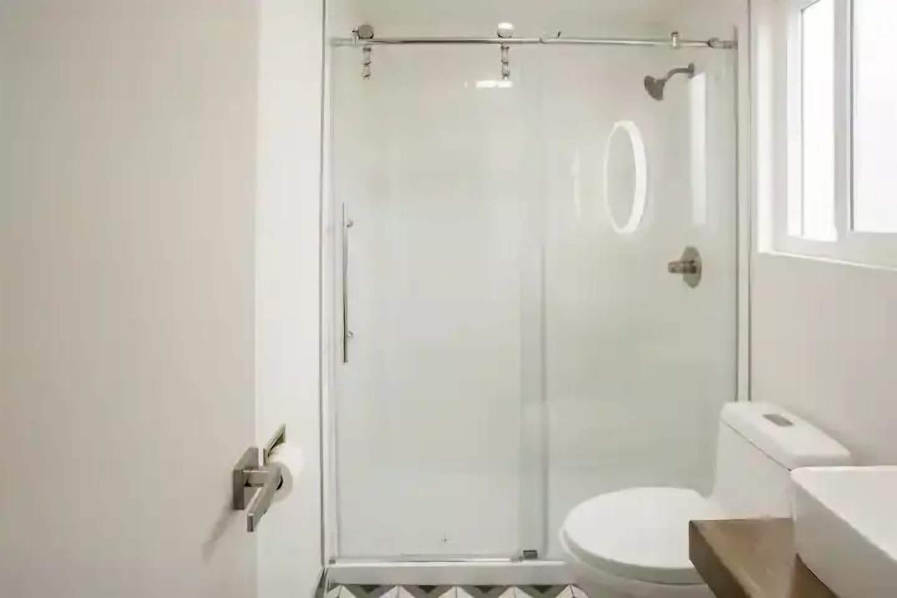 Une salle de bain moderne avec une douche à parois de verre, des toilettes et un lavabo.