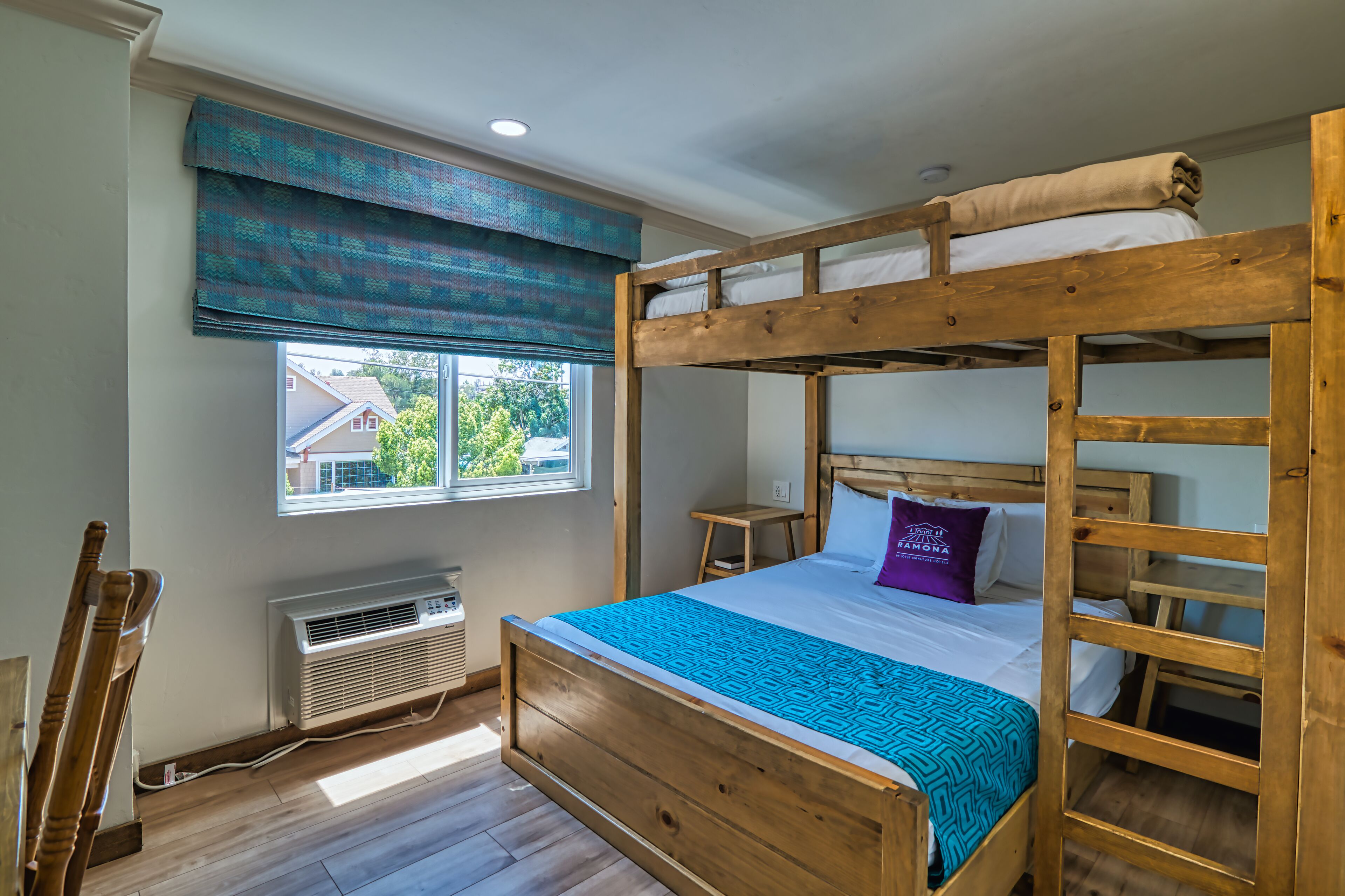 Habitación con literas, ventana, calefacción y una silla.