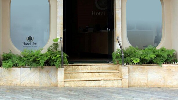 The entrance to Hotel Jaú with a large arched doorway, two large windows on either side, and a sign above the entrance. - Hotel Jau (Jau)