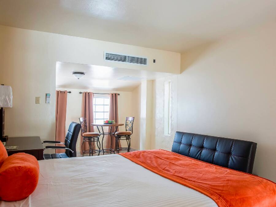 Une chambre d’hôtel avec un grand lit, un bureau et une chaise.