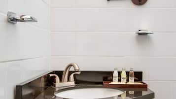A bathroom with a sink, mirror, and toiletries.